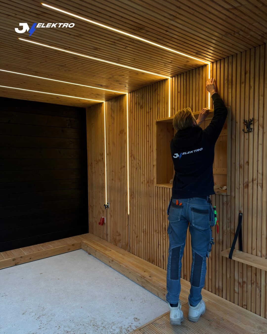 Jason monteert ledstrips in een met hout beklede overkapping